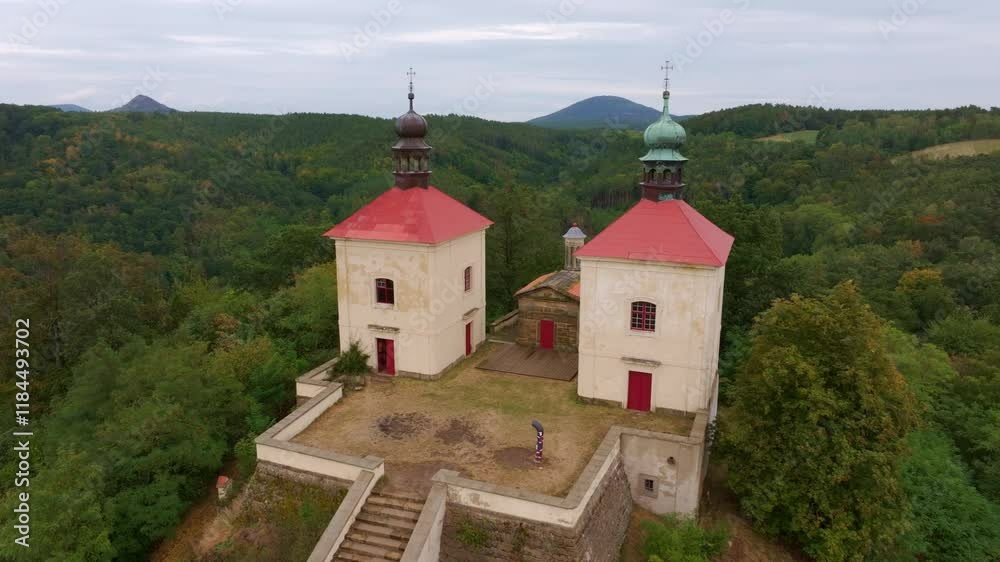 Aerial view of calvary ostre church surrounded by scenic forest and hills, Ustek, Czech Republic.