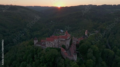 Aerial view of Pernstejn Castle at sunset surrounded by serene forests and picturesque hills, Nedvedice, Czech Republic. photo