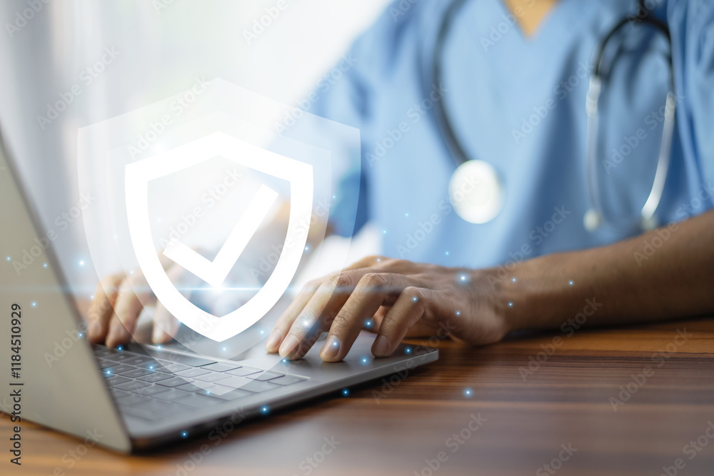Doctor typing on a laptop with a glowing shield icon, symbolizing cybersecurity and data protection in healthcare.