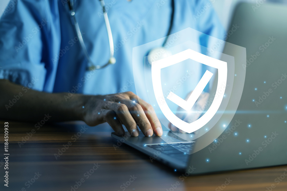 Doctor typing on a laptop with a glowing shield icon, symbolizing cybersecurity and data protection in healthcare.