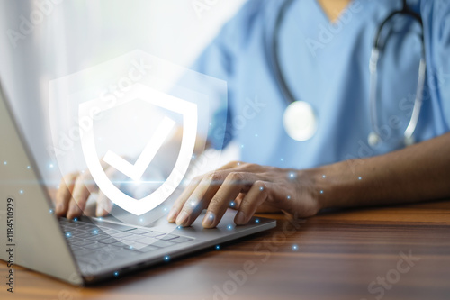 Obraz na płótnie Doctor typing on a laptop with a glowing shield icon, symbolizing cybersecurity and data protection in healthcare. w salonie