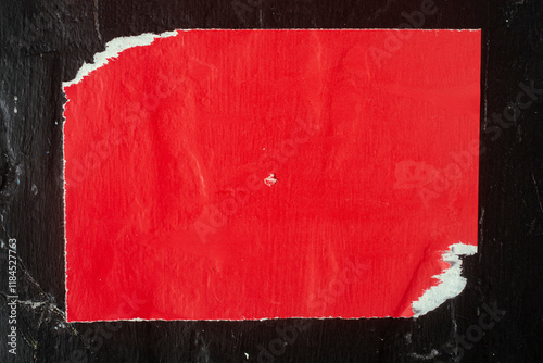 Old red poster on a black wall.