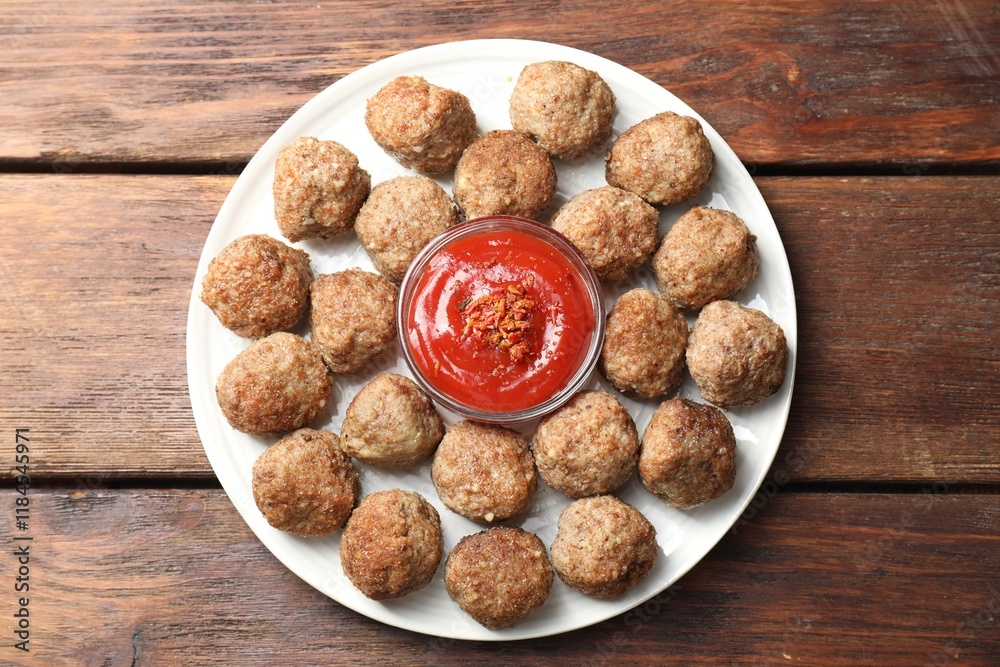 Delicious meatballs with ketchup and spices on wooden table, top view Delicious meatballs with ketchup and spices on wooden table, top view