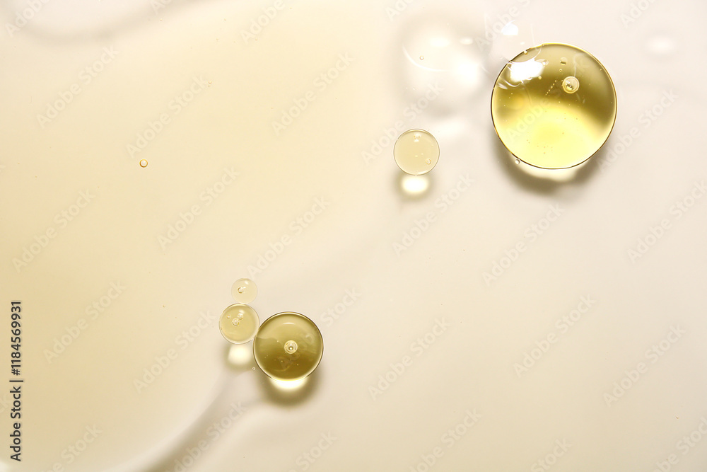 Yellow oil droplets on a smooth white surface in natural light Yellow oil droplets on a smooth white surface in natural light