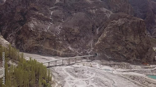 Aerial view of Attabad Lake surrounded by majestic mountains and a scenic bridge in a remote valley, Gojal region, Pakistan. photo