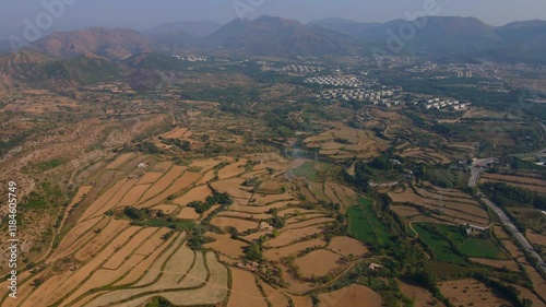 Aerial view of the Dharmarajika Stupa ruins surrounded by scenic farmland and mountains in the Pothohar region, Taxila, Pakistan. photo