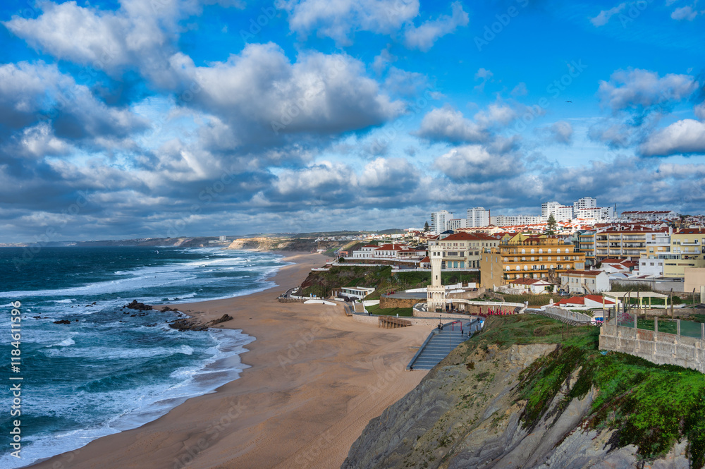 Fototapeta premium Breathtaking view of Santa Cruz Beach, Portugal, with ocean waves, golden sand, cliffs, and greenery.