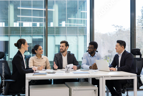 Diverse business colleagues and partners sitting at tables in meeting room, people happily discussing new startup and business investment, company employees with boss in business suit.