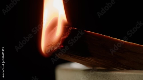 Person holding Palo Santo wood stick in hand, aromatic Palo Santo burning on black background, smoke spreading around, slow motion video clip, high quality 4k close up footage