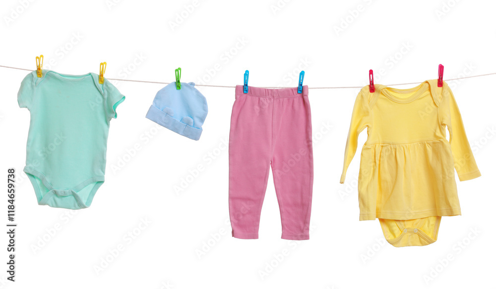 Different baby clothes drying on laundry line against white background Different baby clothes drying on laundry line against white background