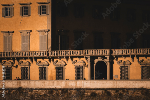 View of ornate historic building with elegant balconies and windows in evening light, Tuscany, Italy. photo