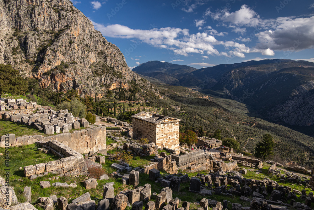 The Athenian Treasury from Delphi Archaeological Site. Wide photo with this historical cultural construction from Delphi, part of Greek history. Photo during a sunny day. Travel to Greece.