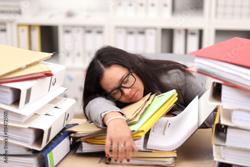 female secretary with glasses sits at the desk and fell asleep from all the work