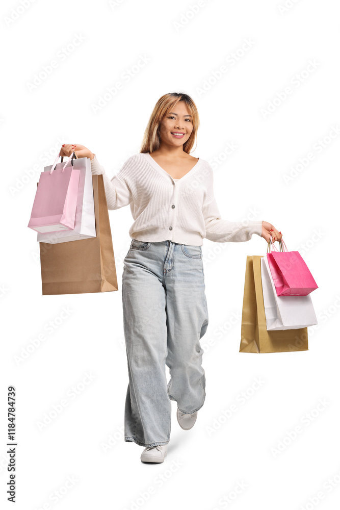Smiling asian woman holding shopping bags and alking towards camera Smiling asian woman holding shopping bags and alking towards camera