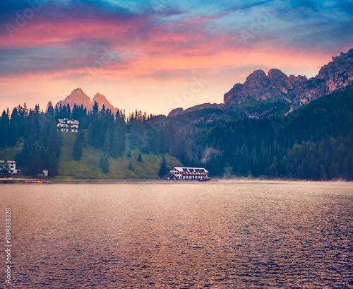 Misty sunrise on Misurina lake with Tre Ceme Di Lavsredo peak on background. Calm autumn cityscape of Misurina village, Italy, Europe. Nice morning scene of Dolomite Alps. photo