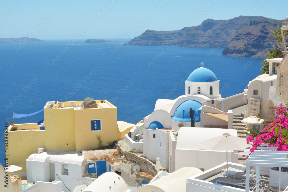 Obraz premium Oia village on Santorini island, Greece. Traditional and famous houses and churches with blue domes over the Caldera, Cyclades islands Aegean sea.