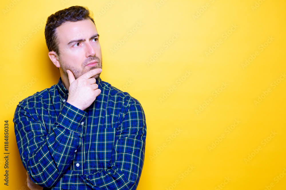One man isolated on yellow background feeling puzzled and doubtful One man isolated on yellow background feeling puzzled and doubtful