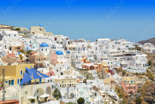 Oia village on Santorini island, Greece. Traditional and famous houses and churches with blue domes over the Caldera, Cyclades islands Aegean sea.