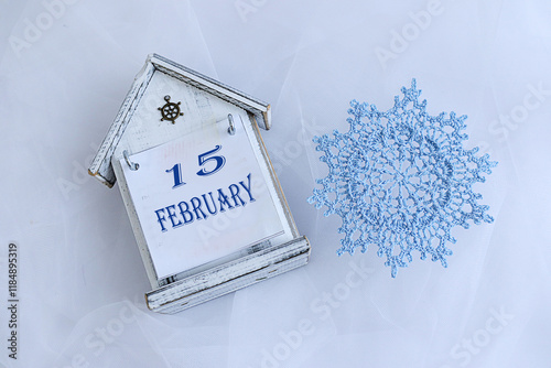 Calendar for February 15: decorative calendar, blue snowflake, numbers 15, name of the month February in English photo