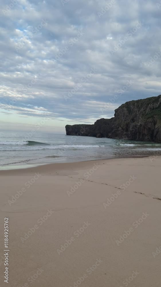 Waves Gently Washing Over Sandy Beach with Scenic Cliffs