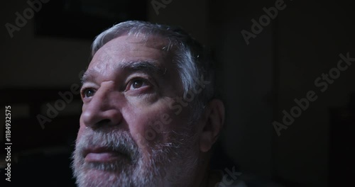 Close up of elderly man gazing upward indoors reflecting in peaceful solitude with thoughtful expression serene mood of introspection and calm