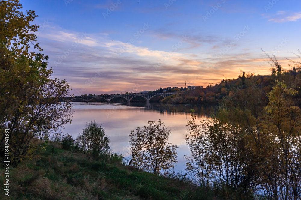 A beautiful sunset over a river with a bridge in the background A beautiful sunset over a river with a bridge in the background