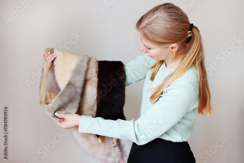 Professional female skinner, furrier working with mink fur skin at atelier, workshop.