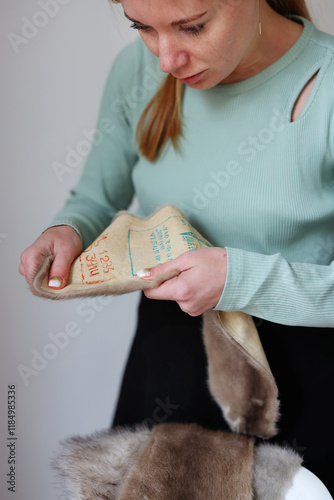 Professional female skinner, furrier working with mink fur skin at atelier, workshop. photo