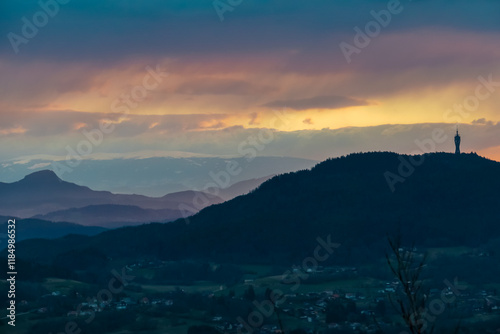 Dramatic sunrise seen from top of Kathreinkogel overlooking Pyramidenkogel and rolling hills of idyllic village Schiefling am See, Carinthia, Austria. Magical atmosphere in remote Austrian Alps photo