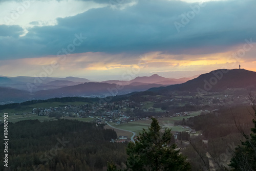 Dramatic sunrise seen from top of Kathreinkogel overlooking Pyramidenkogel and rolling hills of idyllic village Schiefling am See, Carinthia, Austria. Magical atmosphere in remote Austrian Alps photo