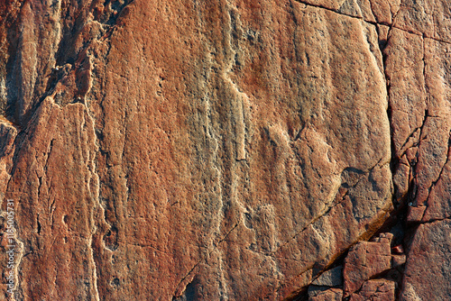 Rock with reddish texture and cracks photo