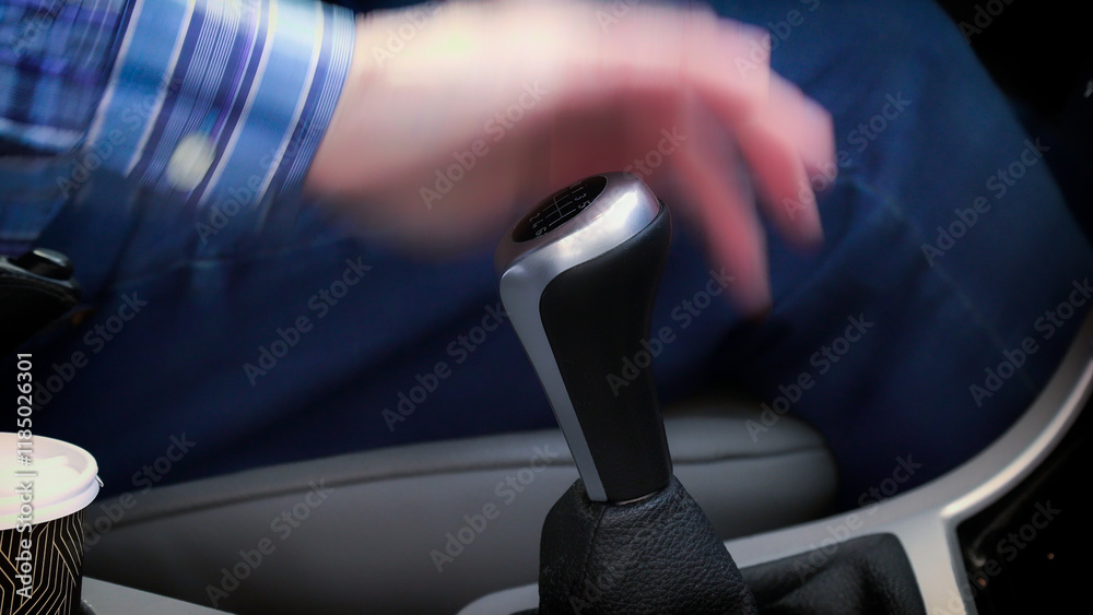 Driver shifting gears in car with motion blur
