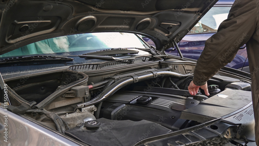 Mechanic inspecting car engine for potential issues