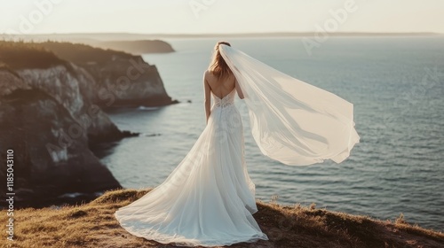 Wallpaper Mural Bride standing on cliff overlooking ocean at sunset with flowing veil in the wind Torontodigital.ca