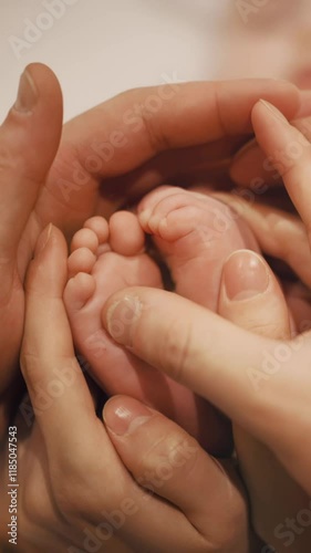 Vertical Video : Baby feet in mother and father hands. Tiny Newborn Baby's feet on female and male hands close up. Mom, Dad and his Child. Happy Family concept. Beautiful conceptual video of Maternity