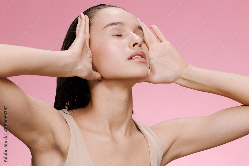 Naklejka premium Serene young model with a natural glow, showcasing emotional tranquility against a soft pink background, embodying beauty and self care concepts