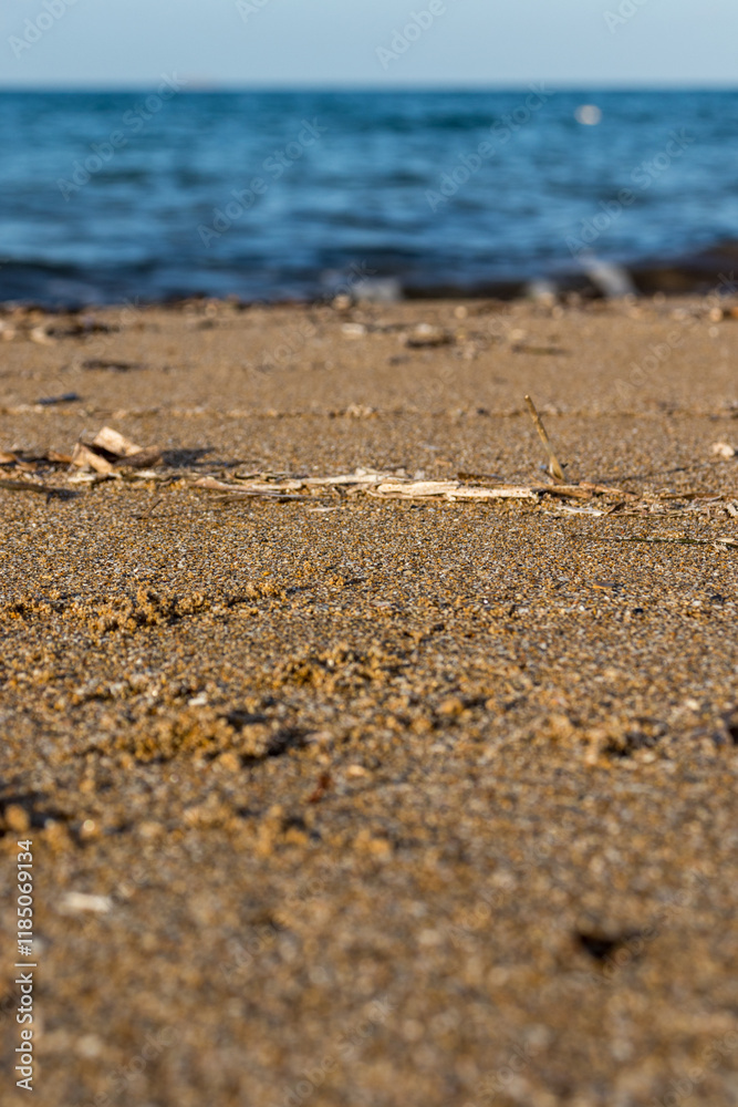 Sandy beach with waves. Close-up view of sand with sea waves in the background
Sandy beach with waves. Close-up view of sand with sea waves in the background