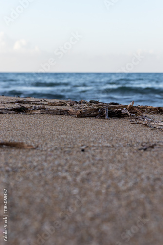 Sandy beach with waves. Close-up view of sand with sea waves in the background