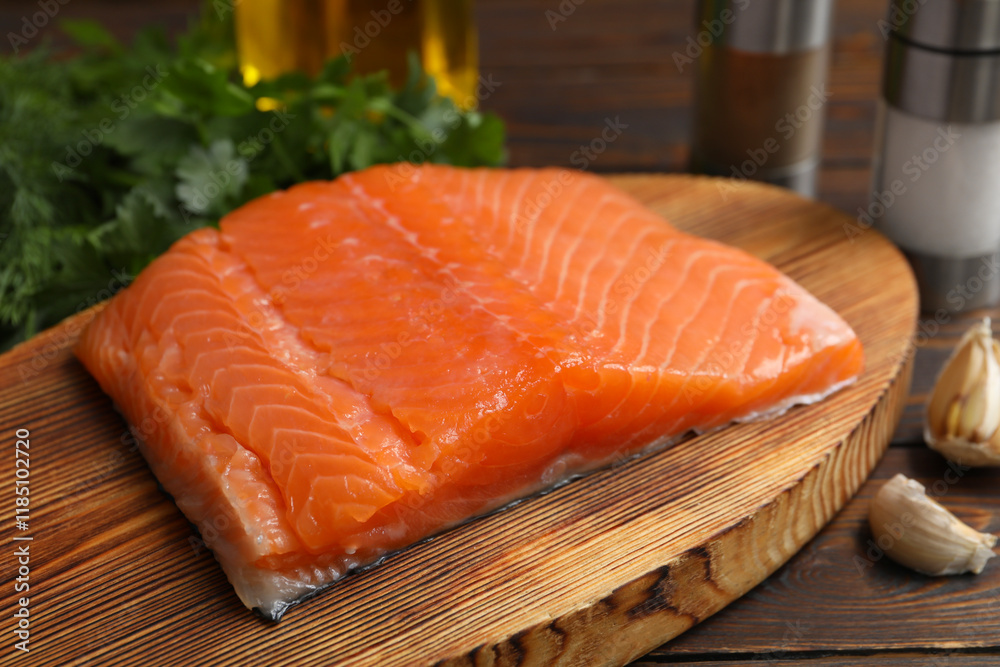 Salmon fillet and spices on wooden table, closeup Salmon fillet and spices on wooden table, closeup