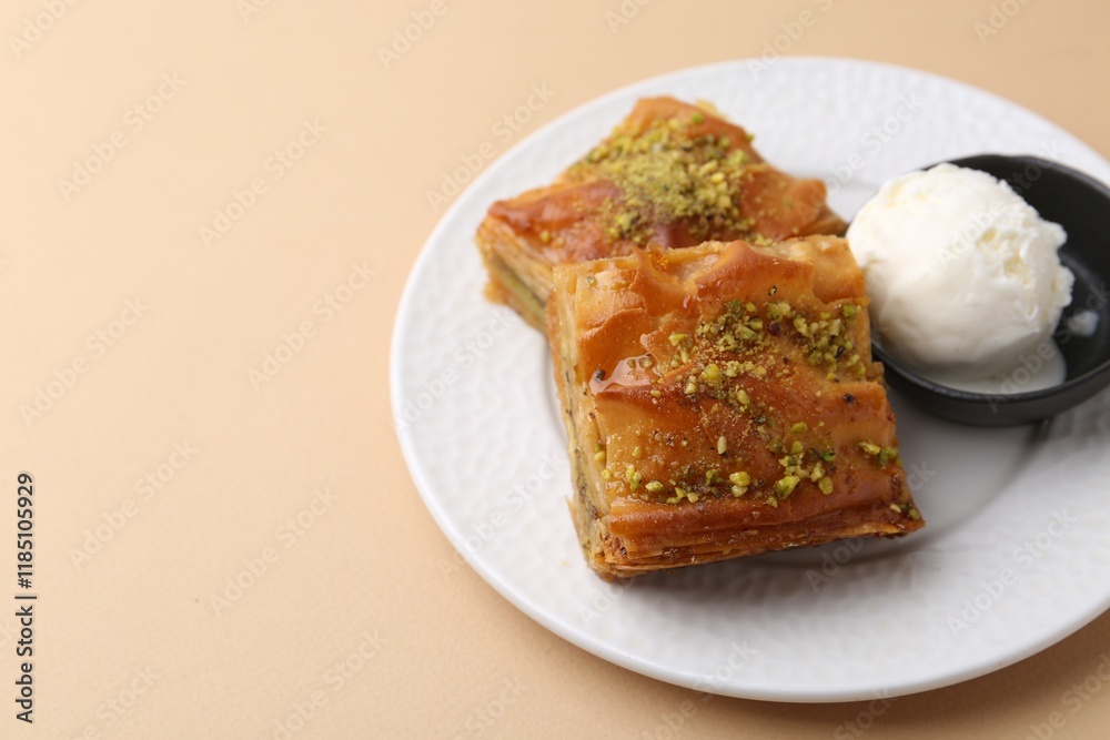 Delicious baklava with crushed nuts and ice cream on beige table, closeup. Space for text Delicious baklava with crushed nuts and ice cream on beige table, closeup. Space for text