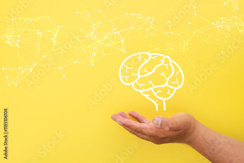 Innovation,Creative idea,Education,AI artificial intelligence concept.,Hand holding human brain with connection line icon over yellow background.,mental health,psychology,thoughtfulness, inspiration.