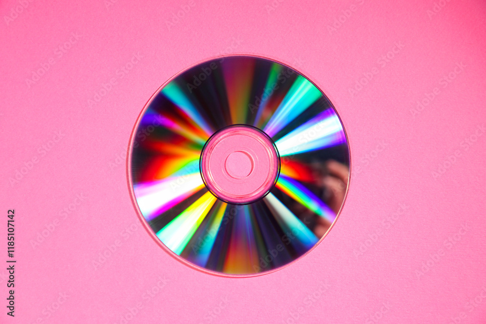 One shiny compact disc on pink background, top view