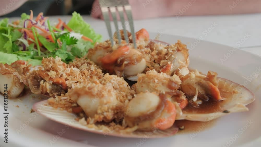 Man eating scallops in street cafe close-up. Man eating scallops in street cafe close-up.
