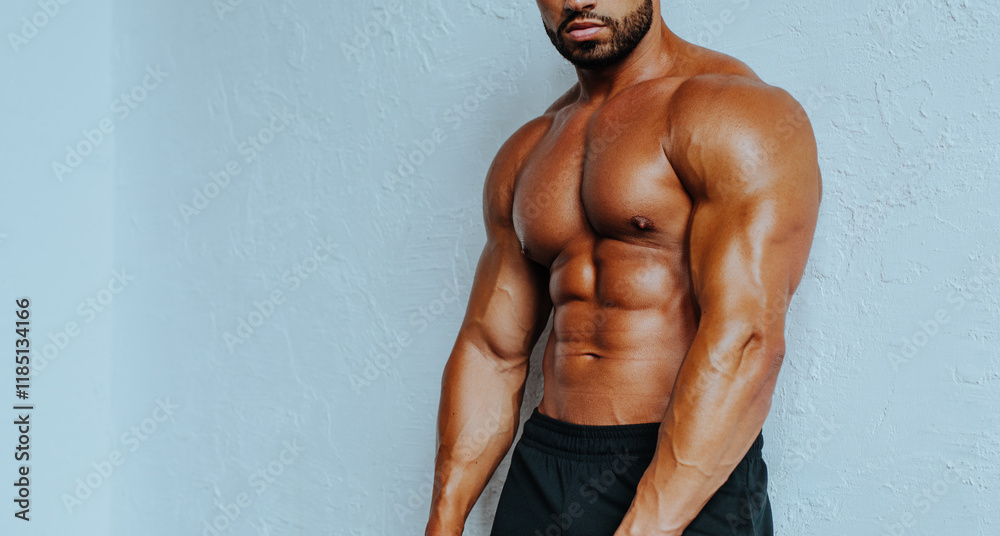 Naklejka premium Young strong man bodybuilder torso on white wall background