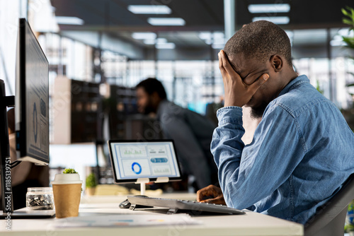 Corporate black CEO experiences job pressure at the office, feeling overwhelmed and stressed by administrative tasks and deadlines. Male expert dealing with low energy and frustration.