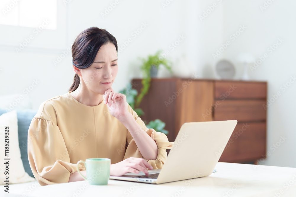 困った表情でパソコンを使う女性 困った表情でパソコンを使う女性
