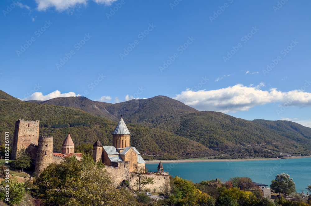 Picturesque view of a historic Ananuri fortress with mountain backdrop and a serene Zhinvali Reservoir beneath a clear blue sky. Georgia Picturesque view of a historic Ananuri fortress with mountain backdrop and a serene Zhinvali Reservoir beneath a clear blue sky. Georgia