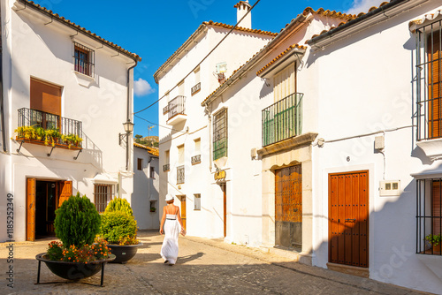 A young woman walks through the historic old town of the Andalusian White Village of Grazalema, Spain in the province of Cádiz.