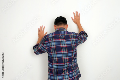 Foto Back view of a man touching a wall showing lamenting fate gesture