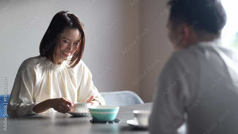 A Japanese couple, a woman in her 30s and a man in his 20s, are enjoying afternoon tea time at home. Slow motion video.